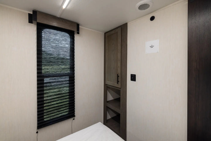 Small bedroom with a window, bed, and wardrobe.