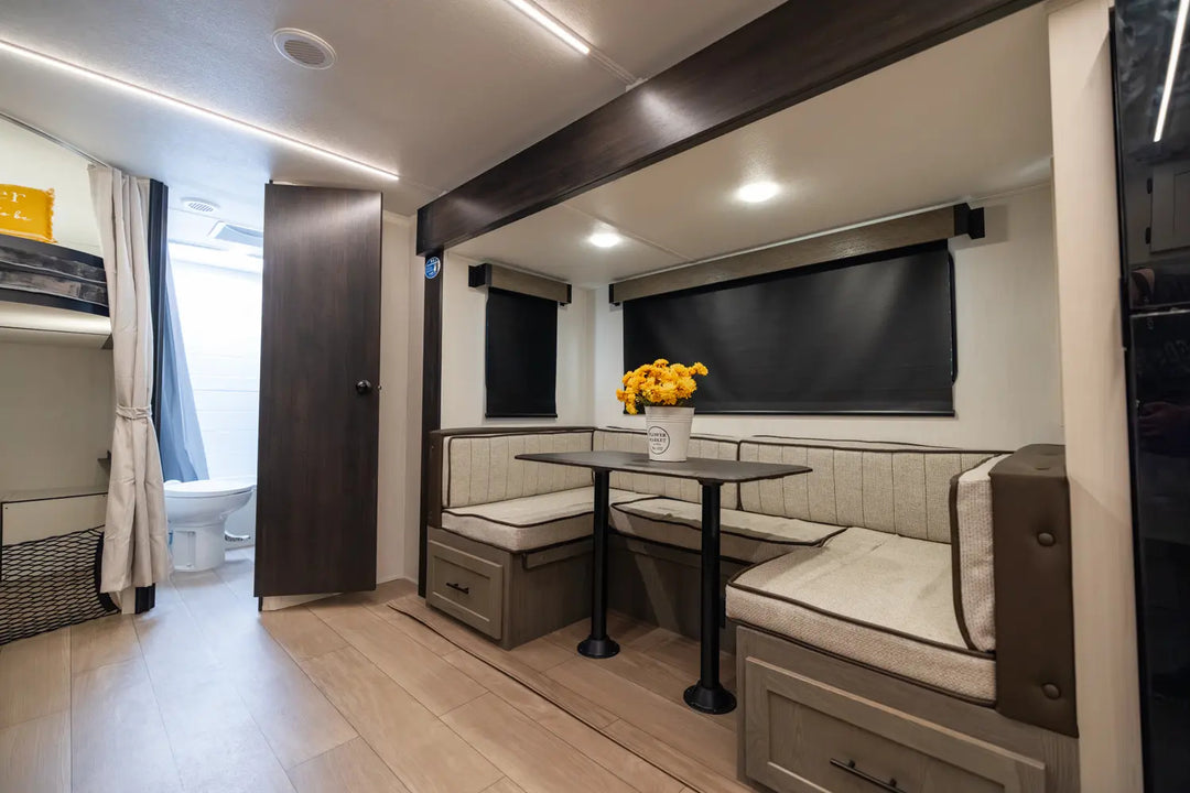 Compact living space with a dining area, kitchenette, and bathroom in a small home.