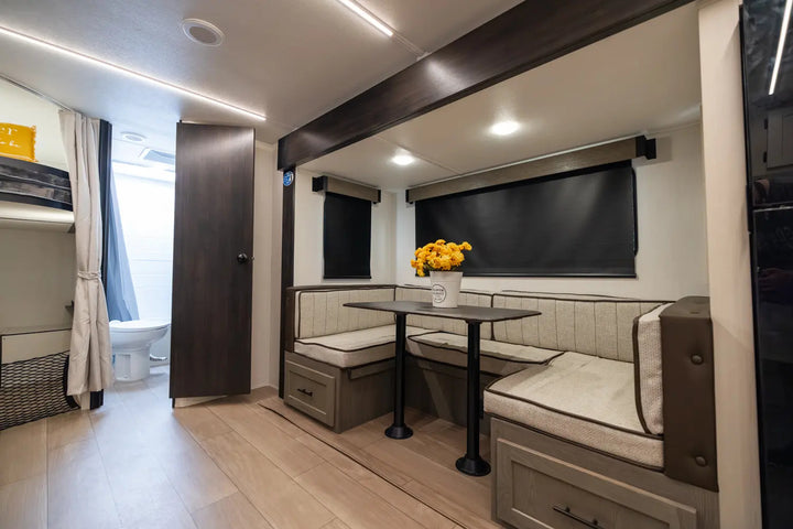 Compact living space with a dining area, kitchenette, and bathroom in a small home.