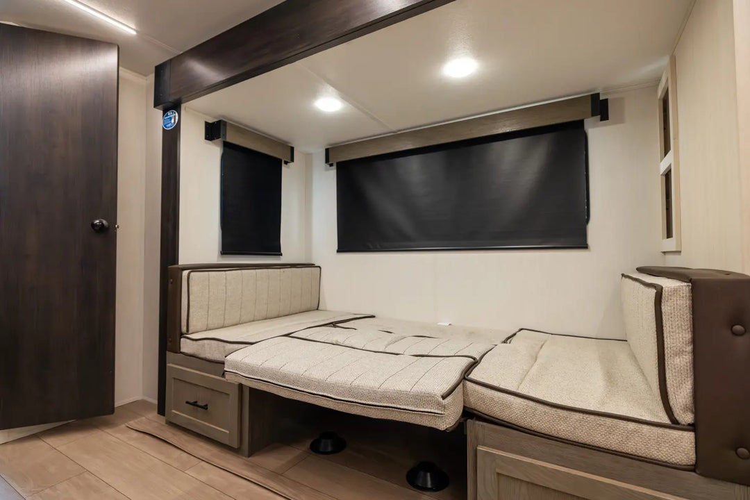 Compact living space with a bed and seating area in a small room.
