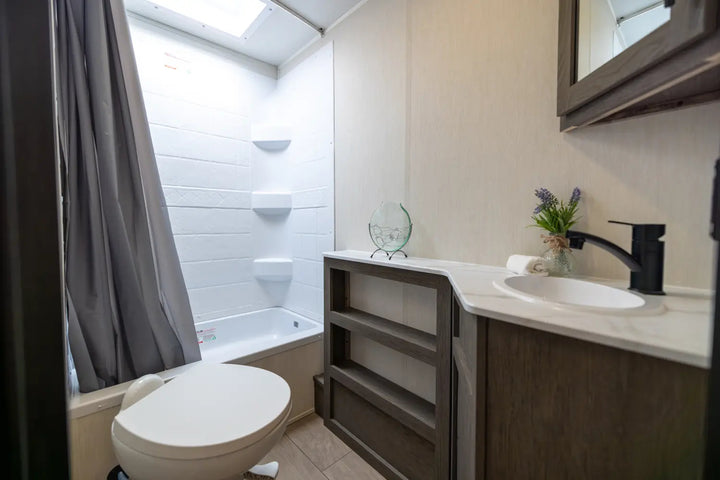 Modern bathroom with toilet, sink, and bathtub.