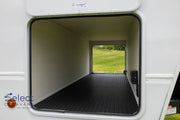 Open door of a recreational vehicle showing a grassy field outside