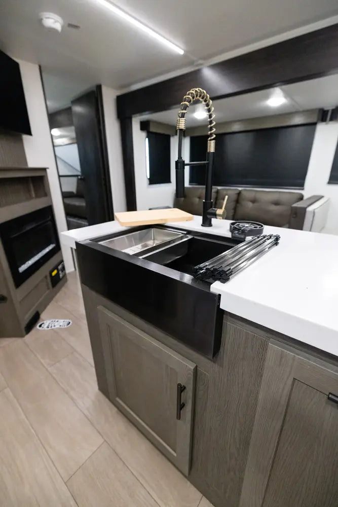 Modern kitchen setup with a large black sink in a vehicle interior.
