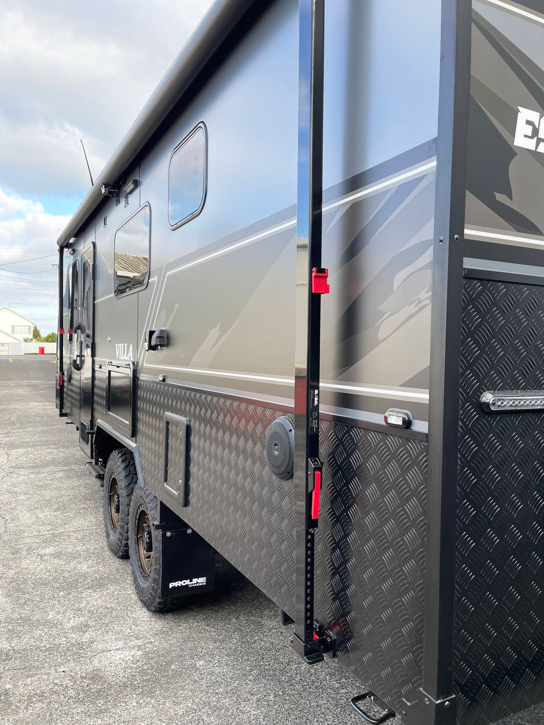 Side view of a large recreational vehicle with a textured door and visible branding.