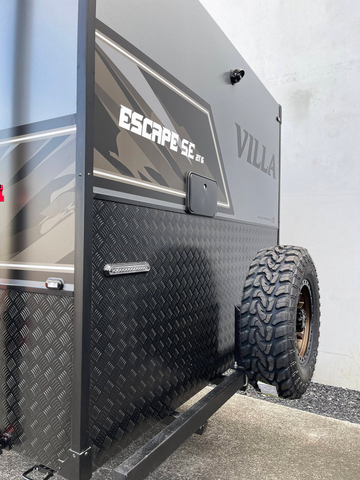Close-up of a black and gray RV with 'Escape SE' and 'Villa' branding.