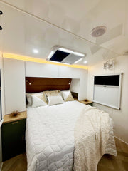 Modern bedroom with a bed, headboard, and wall-mounted TV.