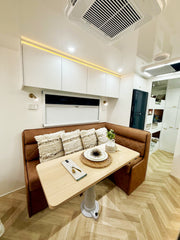 Modern kitchen interior with a brown leather bench and wooden dining table.
