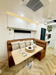 Modern kitchen interior with a brown leather bench and wooden dining table.