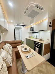 Modern kitchen and living area with a dining table, sofa, and appliances.