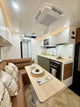 Modern kitchen and living area with a dining table, sofa, and appliances.