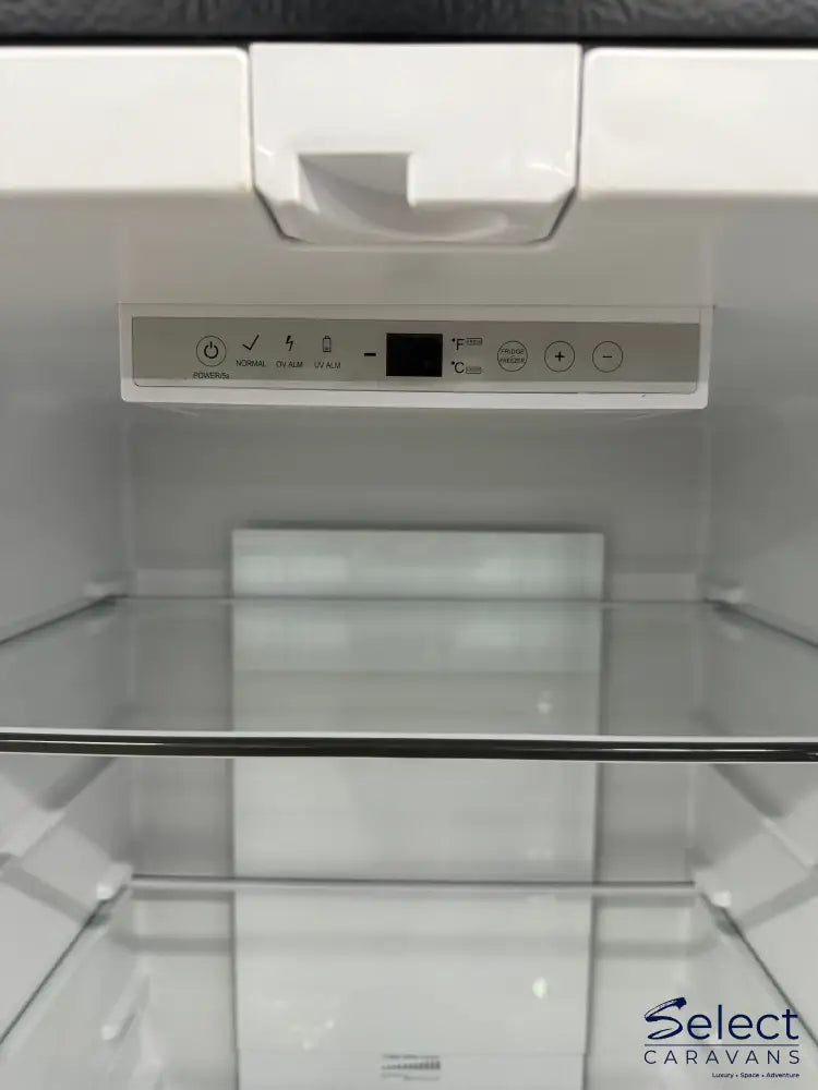 Close-up of a refrigerator control panel with a glass door in the background