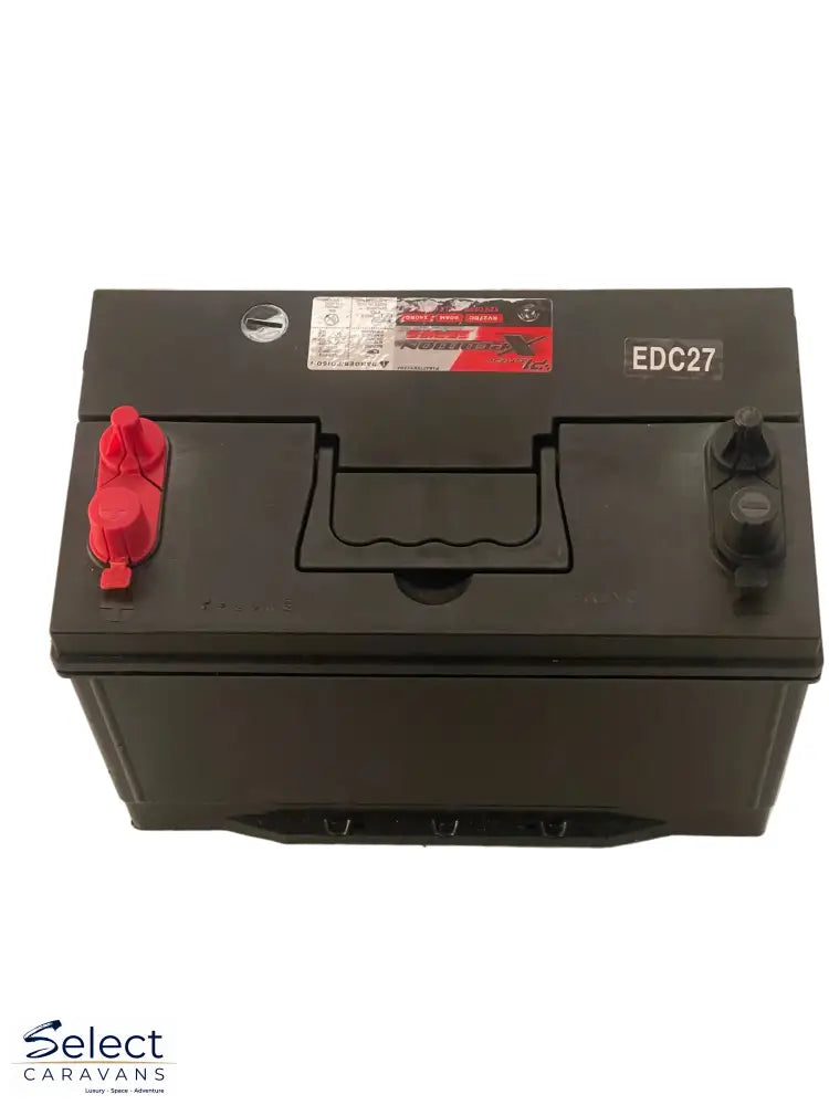 Black battery with red terminals on a white surface