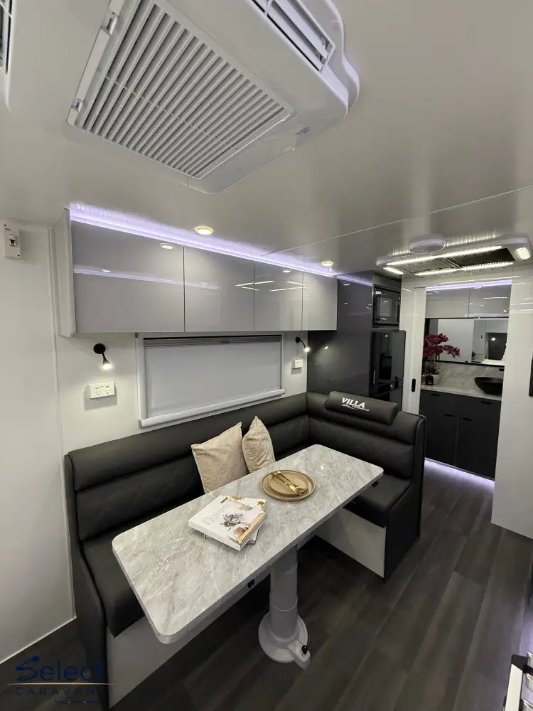 Modern interior of a vehicle with a dining area, kitchen, and living space.