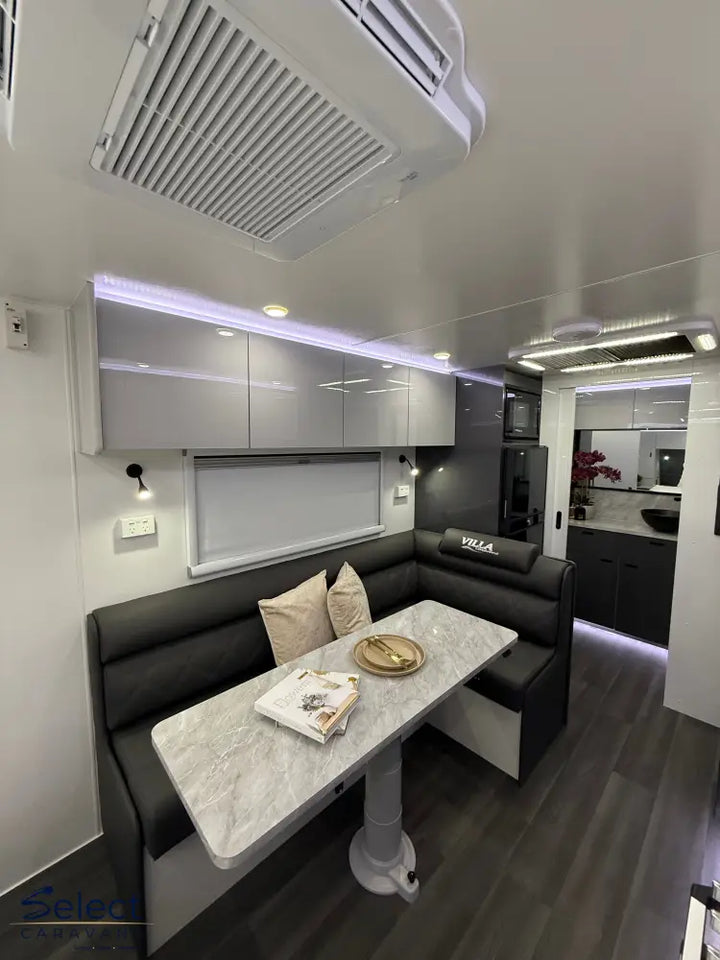 Modern interior of a vehicle with a dining area, kitchen, and living space.