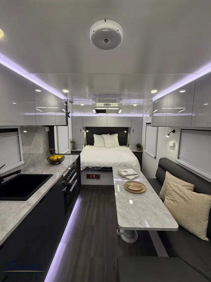 Modern interior of a compact living space with a bed, kitchen area, and seating.