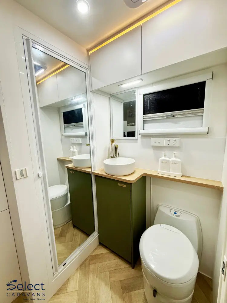 Modern bathroom interior with vanity, mirror, and toilet.