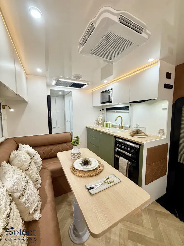 Modern kitchen and living area with a dining table, sofa, and appliances.