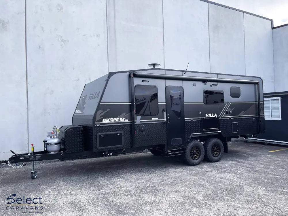 Black Villa caravan parked in front of a gray building