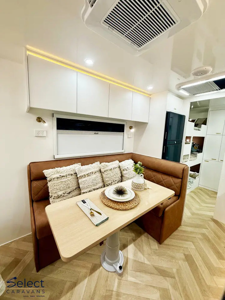 Modern kitchen interior with a brown leather bench and wooden dining table.
