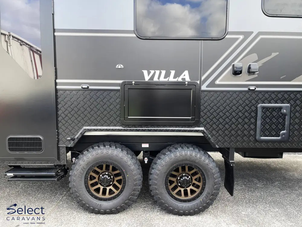 Black and gray caravan with 'Villa' branding on a cloudy day